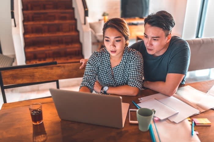 Two people looking at laptop and discussing something.