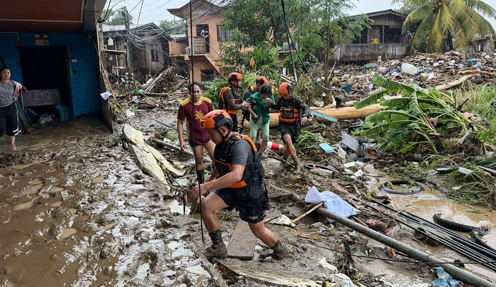 Rescuers evacuate a woman from her flooded home in Iligan, Lanao del Norte province on February 6. Photo: AFP