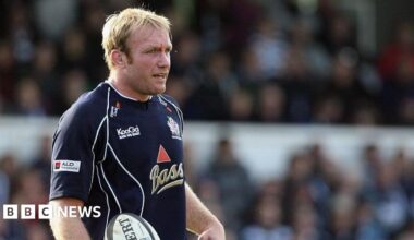 Matt Salter during a rugby match standing and holding the ball, he has a cut in the middle of his eyebrow