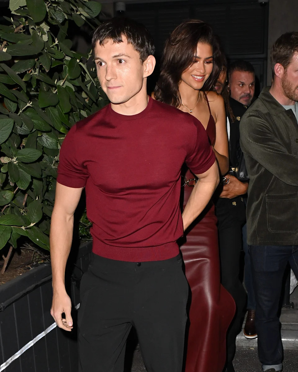 Tom Holland leads Zendaya outside of a bar