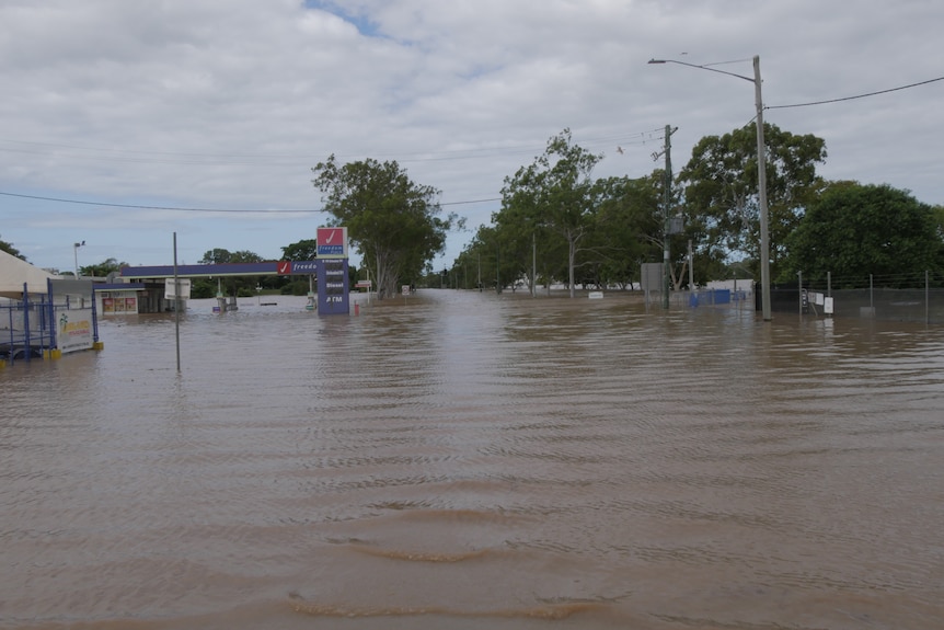 A petrol station mostly submerged in floodwater