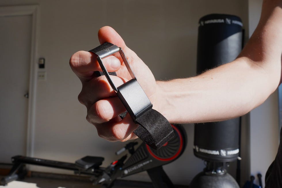 a person holding a strap with a metal buckle in a gym setting