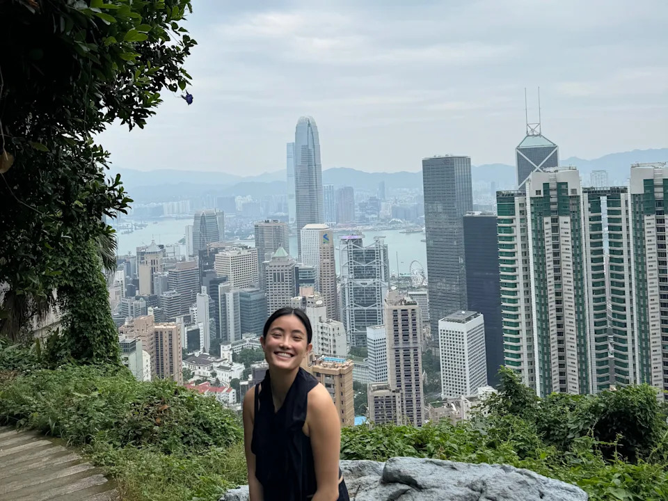 A woman posing with the Hong Kong skyline.