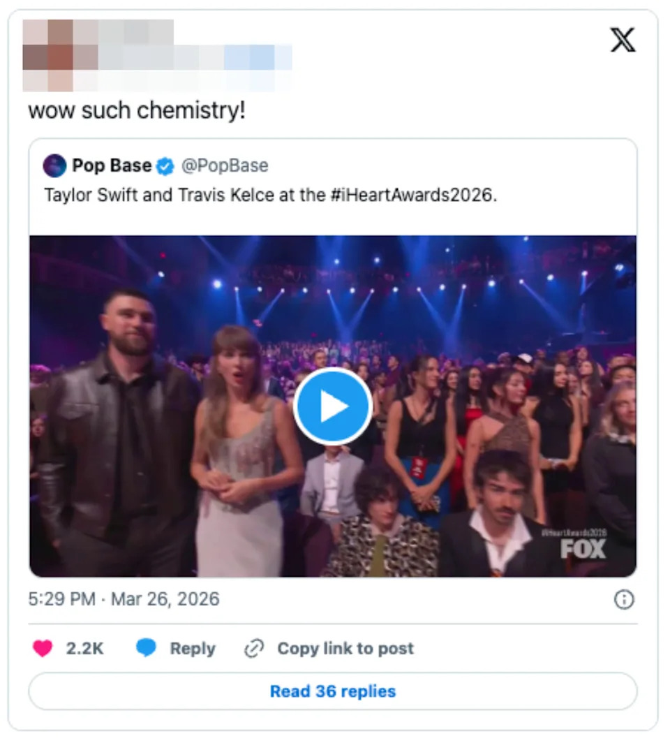 Taylor Swift and an unidentified man sit in an audience at an award show. They appear to be engaged and attentive