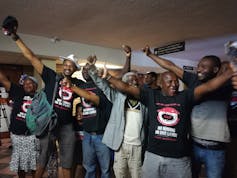 Activists wearing tshirts that say 'No mining on our land' celebrating