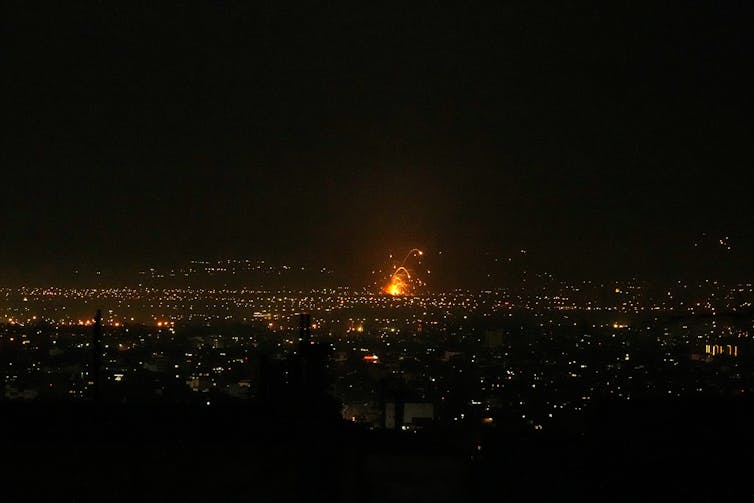 An explosion lights up a city at night