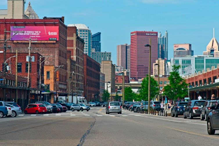 The silhouette of a city in the background of a busy street.