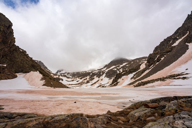 snowy mountain valley, with orange dust