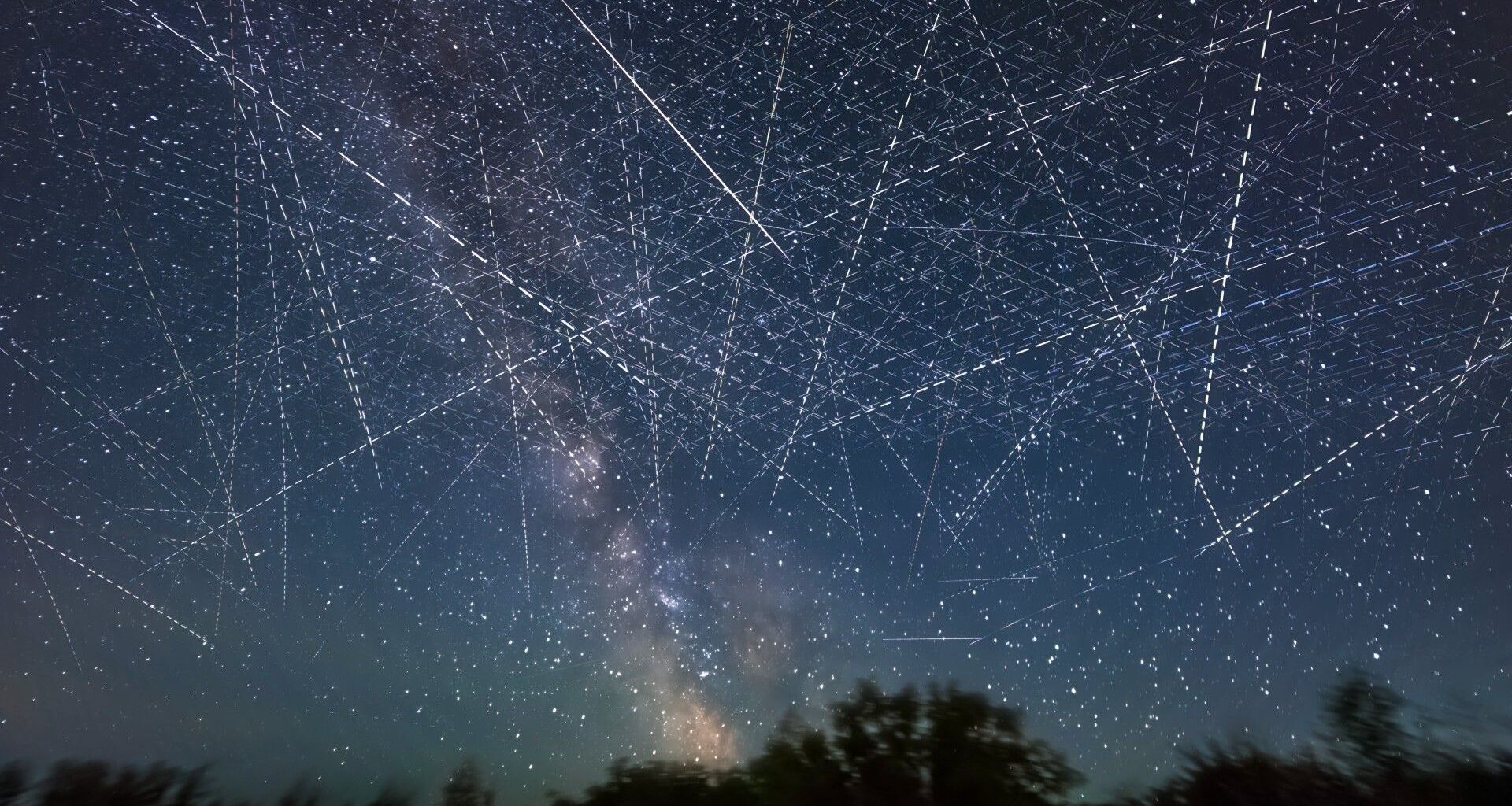 streaks of light crisscross a starry night sky