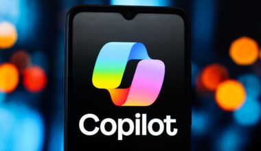 Copilot logo on a black smartphone in front of blue background with multicolored dots.