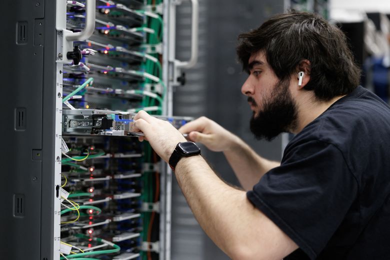 An employee pulls out a server rack shelf at the rear of a Trainium3 UltraServer at an Amazon Web Services QA lab in Austin, Texas, on February 3, 2026.