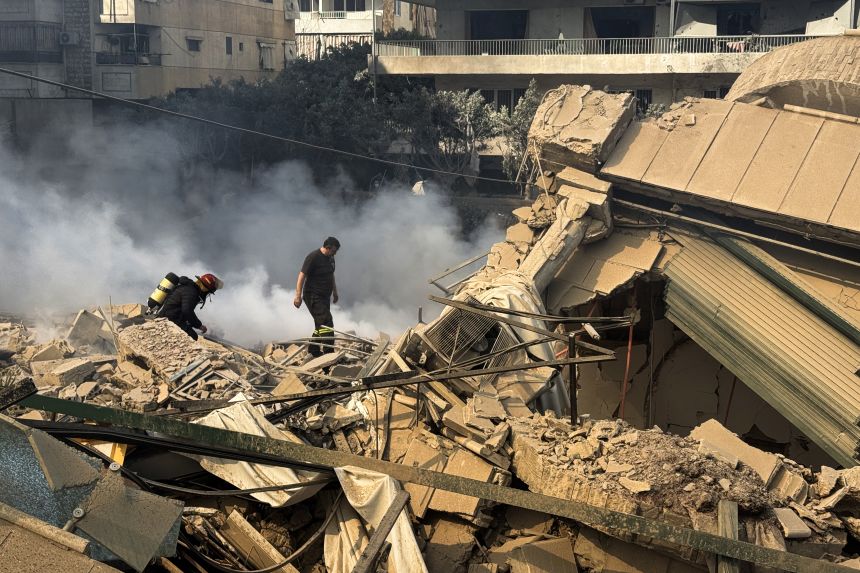 Firefighters inspect destruction at the site of an Israeli airstrike in the southern suburbs of Beirut, Lebanon, on March 3, 2026.