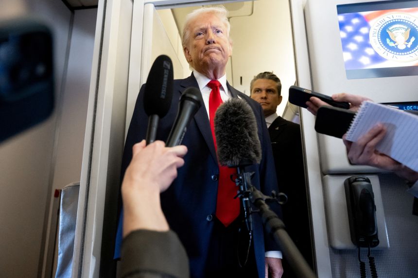 US President Donald Trump speaks with the media as Defense Secretary Pete Hegseth looks on aboard Air Force One during a flight from Dover, Delaware, to Miami, Florida, on March 7, 2026.