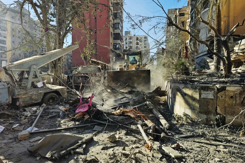 A bulldozer clears the debris of destroyed buildings at the site of an Israeli airstrike that targeted Rweiss neighbourhood in Beirut's southern suburbs, on March 8, 2026.