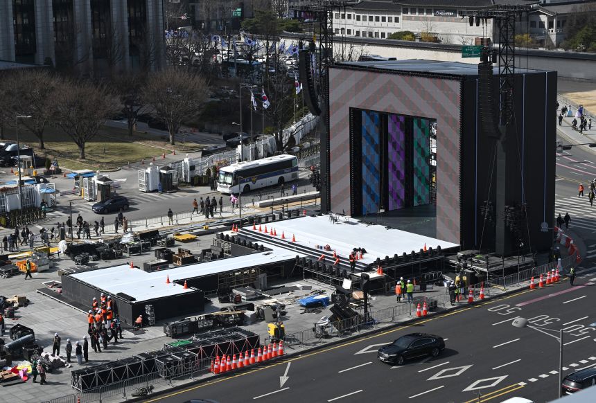 Workers set up the stage for BTS' comeback concert at Gwanghwamun Square. The extravaganza is expected to be watched by hundreds of thousands of fans attending and millions online.