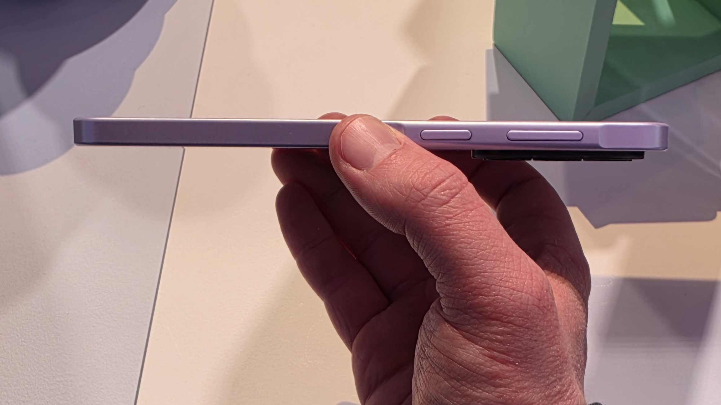 The Samsung Galaxy A37 in a man's hand, showing its side.