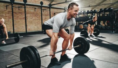 Three people doing a barbell deadlift during gym workout
