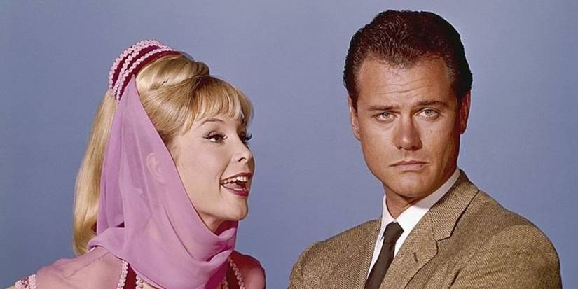 Barbara Eden talks at Larry Hagman who looks ahead with a plain background in I Dream of Jeannie.