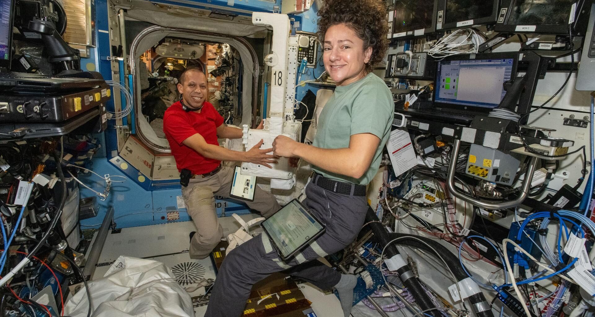 NASA astronauts Chris Williams and Jessica Meir, both Expedition 74 flight engineers, inspect and configure a spacesuit jetpack, known as the Simplified Aid for EVA Rescue (SAFER), inside the International Space Station’s Destiny laboratory module. The jetpacks attach to the rear of spacesuits and serve as a safety mechanism that allows a spacewalker to maneuver back to the station in the unlikely event they become untethered from their worksite.