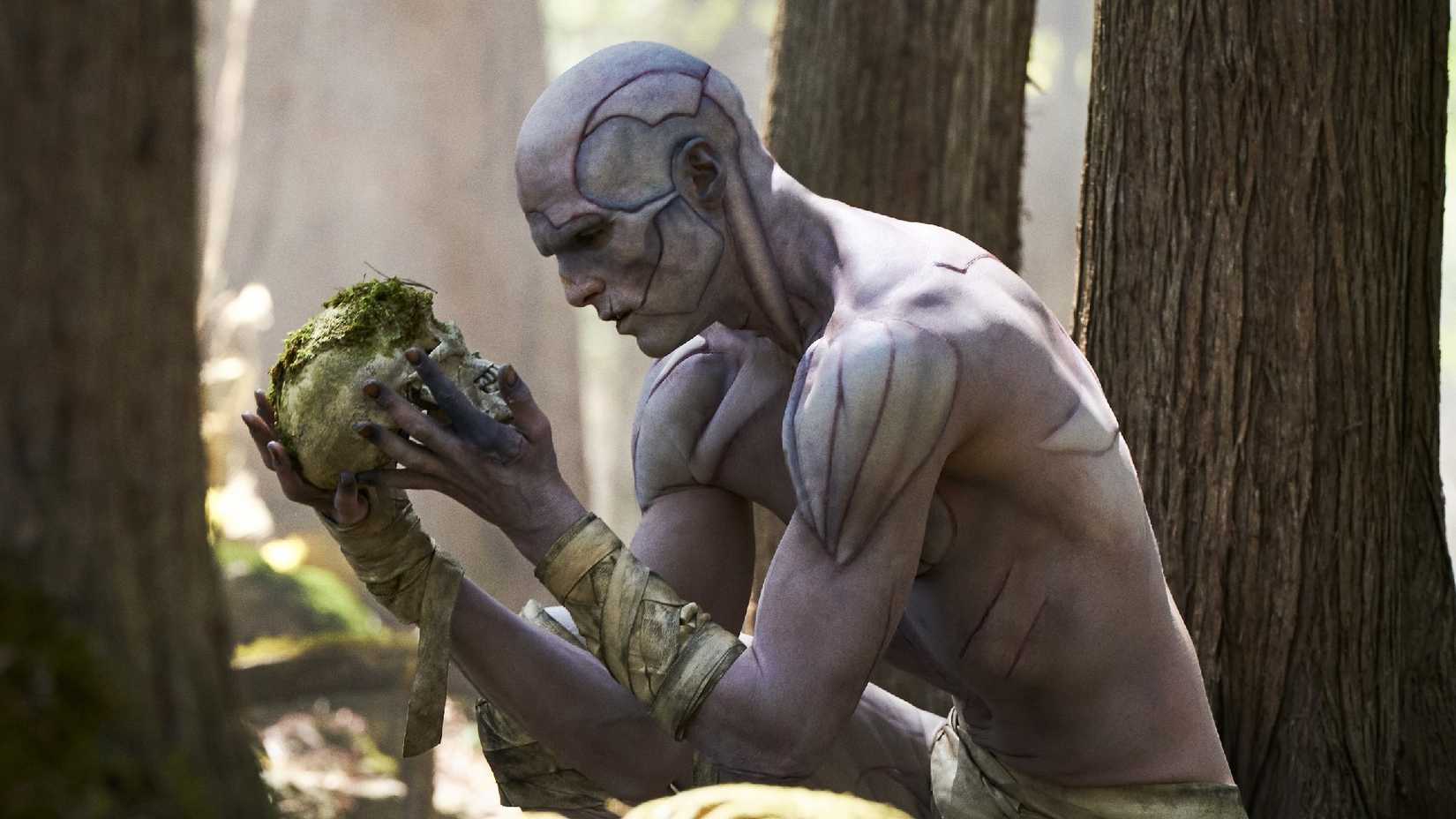 Jacob Elordi's Monster holding a skull in Frankenstein