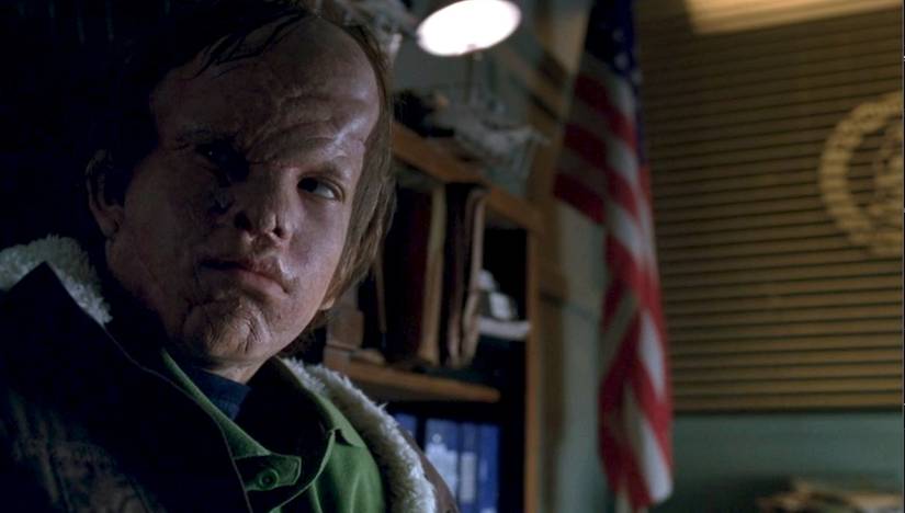 A deformed child sits in a state trooper's office in the Fringe episode "Johari Window"