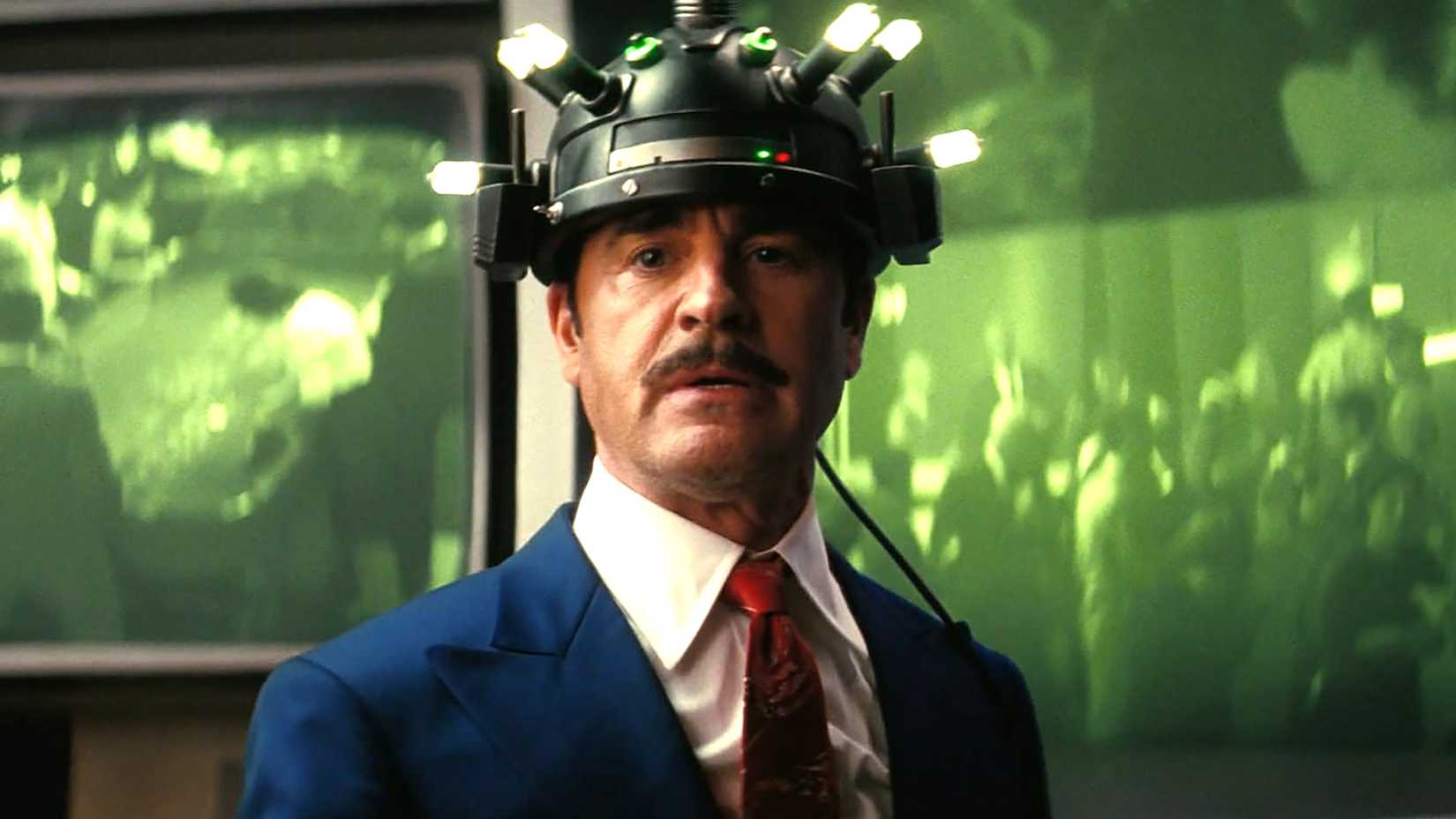 Justin Theroux's Mr. House with a device on his head standing in front of a big screen in Fallout season 2
