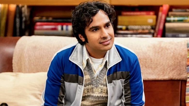 Raj sitting on the couch smiling on The Big Bang Theory