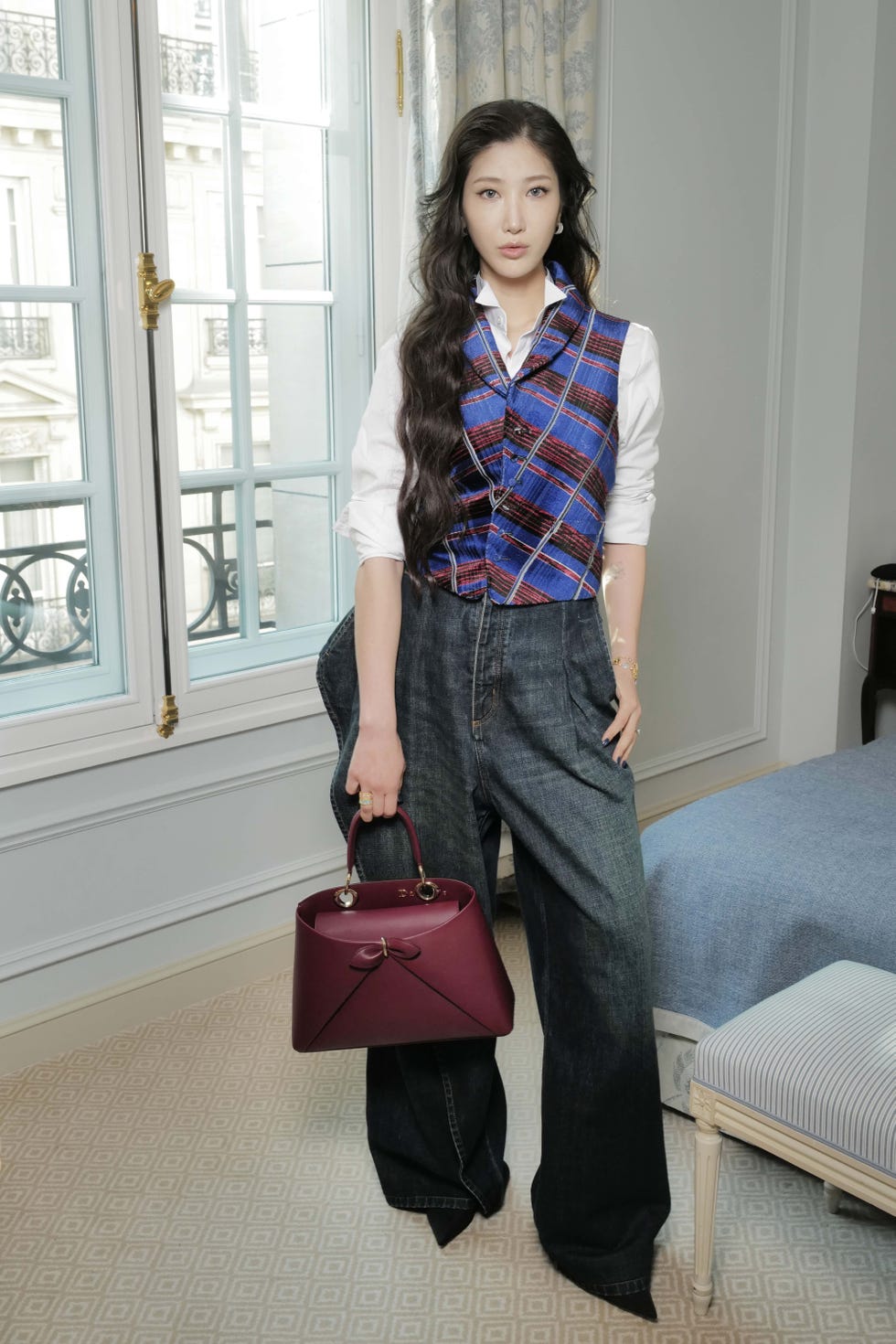 a person wearing a stylish outfit stands in a welllit room