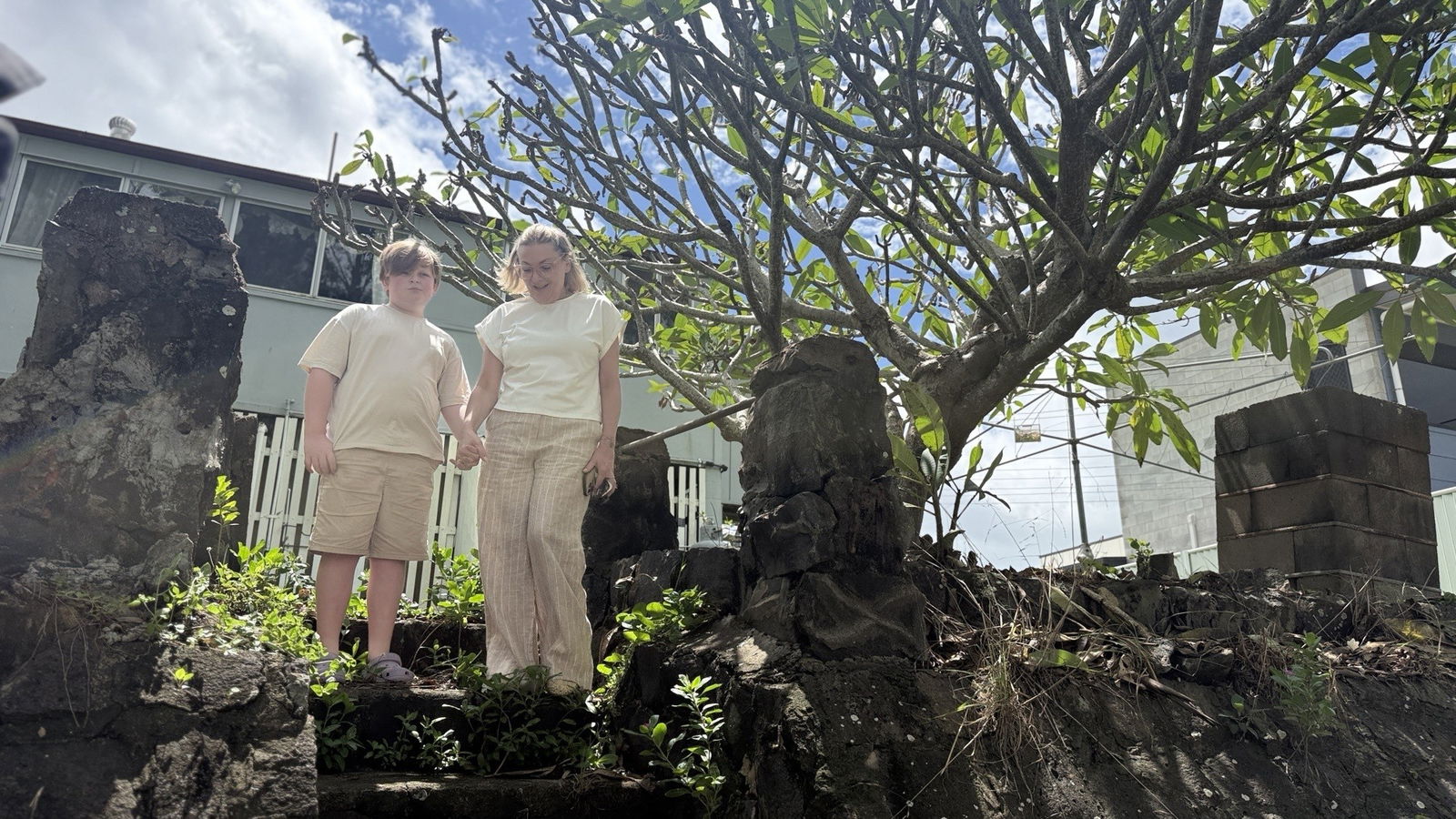 a mum and son look at the river in front of their house