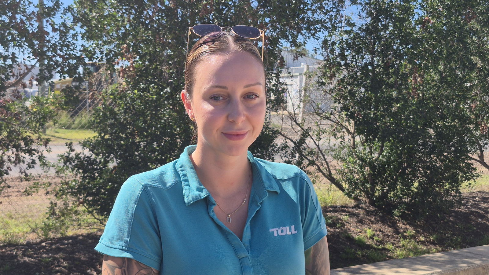 a woman with a blue polo smiles at the camera
