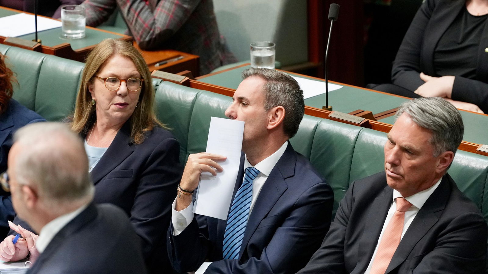 Chalmers places a sheet of paper by his mouth
