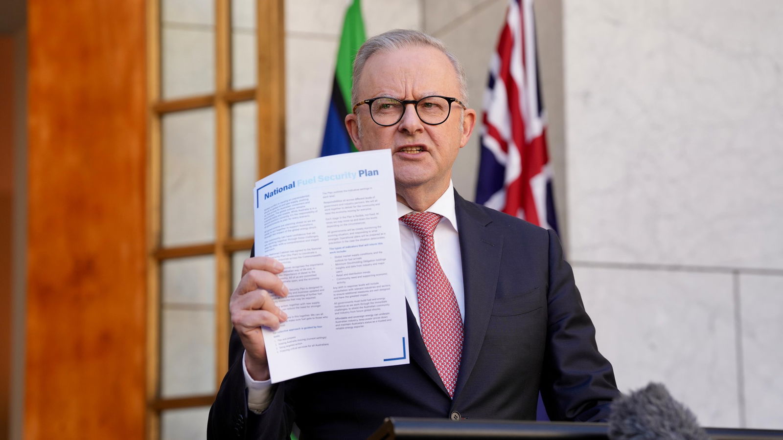 Albanese holds us a piece of paper while speaking at a press confernece.