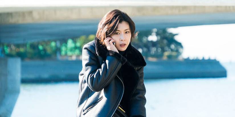 Sara "Sherlock" sitting on a curb talking on the phone in Miss Sherlock.