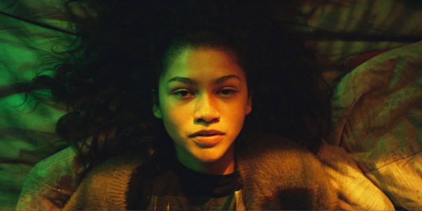 Mouse offering Rue a drug while she sits on the couch in Euphoria