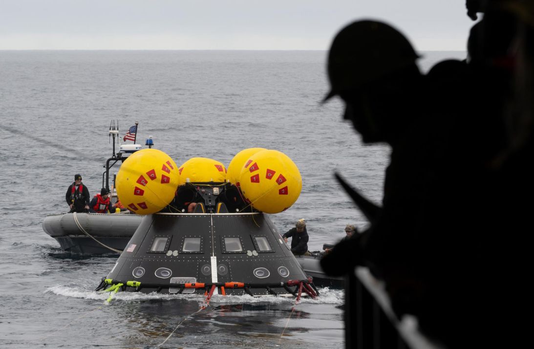 Teams prepare to recover the capsule after splashdown with a replica of the Orion spacecraft.