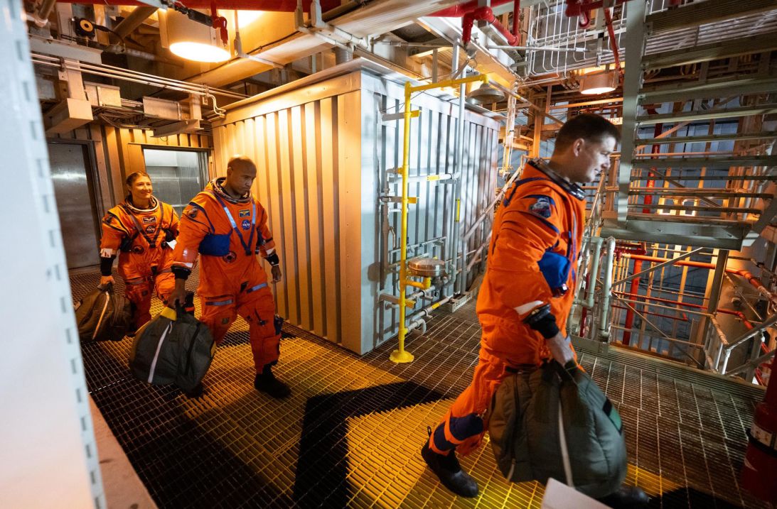 (From left) NASA’s Christina Koch and Victor Glover and the Canadian Space Agency’s Jeremy Hansen walk toward the crew access arm.