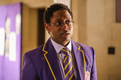 A young man in a school uniform looks nervous.