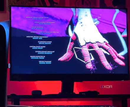 An image of a PlayStation 5 console sitting beside a monitor screen with red lights in the background.