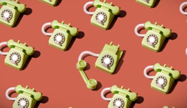 High angle view of some vintage green rotary telephones arranged on a brown background, showcasing retro communication technology with a nostalgic and artistic flair