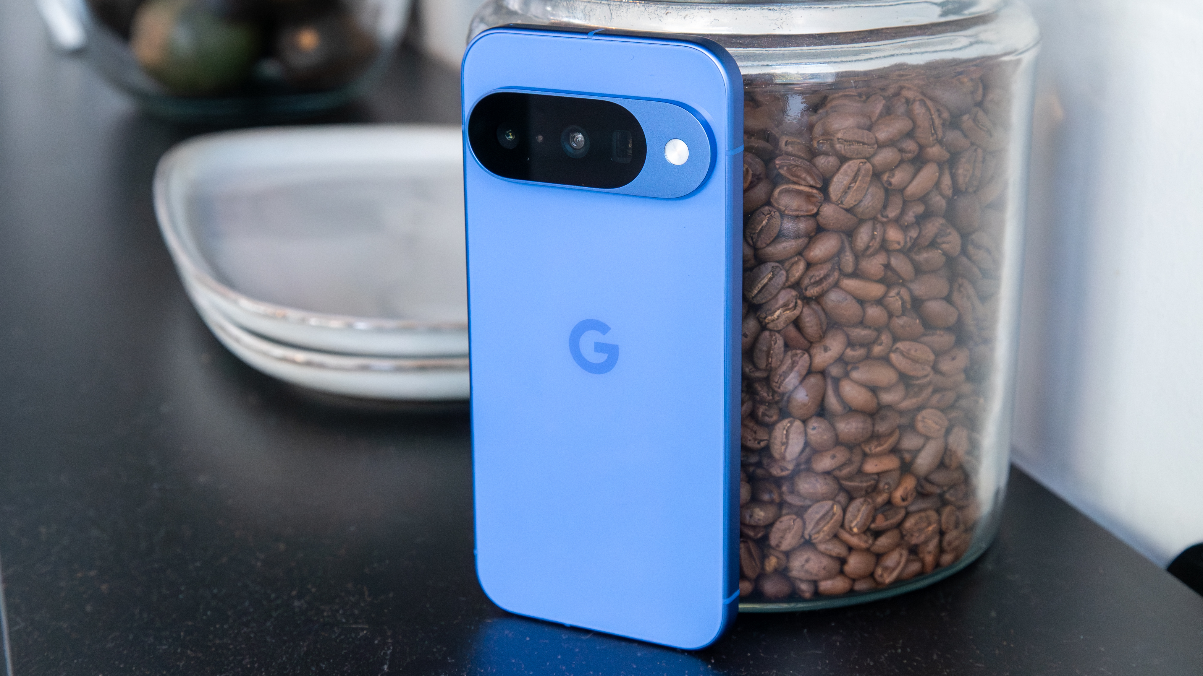 Pixel 10 next to a glass jar of coffee beans