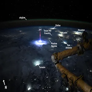 In this photo, the "gigantic jet" TLE storm with red sprites appears to be hovering near the Texas–Mexico border. You can spot the glow of Dallas, Austin, San Antonio, and Houston to the northeast, and Torreón, Mexico, to the southwest. Credit: NASA/Nichole Ayers