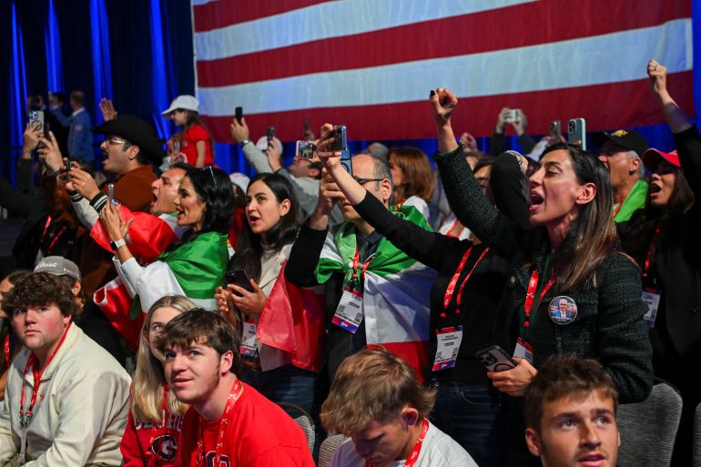 People wrapped in pre-Iranian Revolution "Lion and Sun" flags listen to a speech of Reza Pahlavi, the exiled son of Iran's last shah and an Iranian opposition figure, during the Conservative Political Action Conference (CPAC) USA 2026 at the Gaylord Texan Resort and Convention Center, in Grapevine, Texas, U.S. March 28, 2026. REUTERS/Callaghan O'Hare