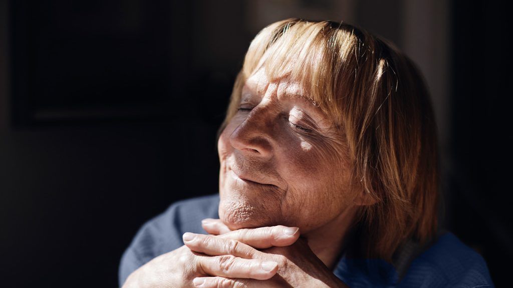 An older person with sunlight on their face.