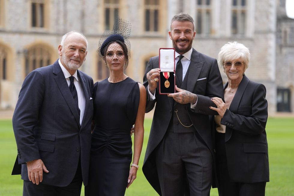 Sir David Beckham poses with his wife Lady Victoria and parents Ted and Sandra Beckham after he was made a Knight Bachelor
