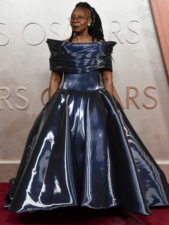 Whoopi Goldberg in an off-the-shoulder blue 'liquid water' organza gown by Christian Siriano in 2025, giving fans a peak of her rarely seen shoulder tattoo (a colourful dragon, in case you're wondering). Pic: AP