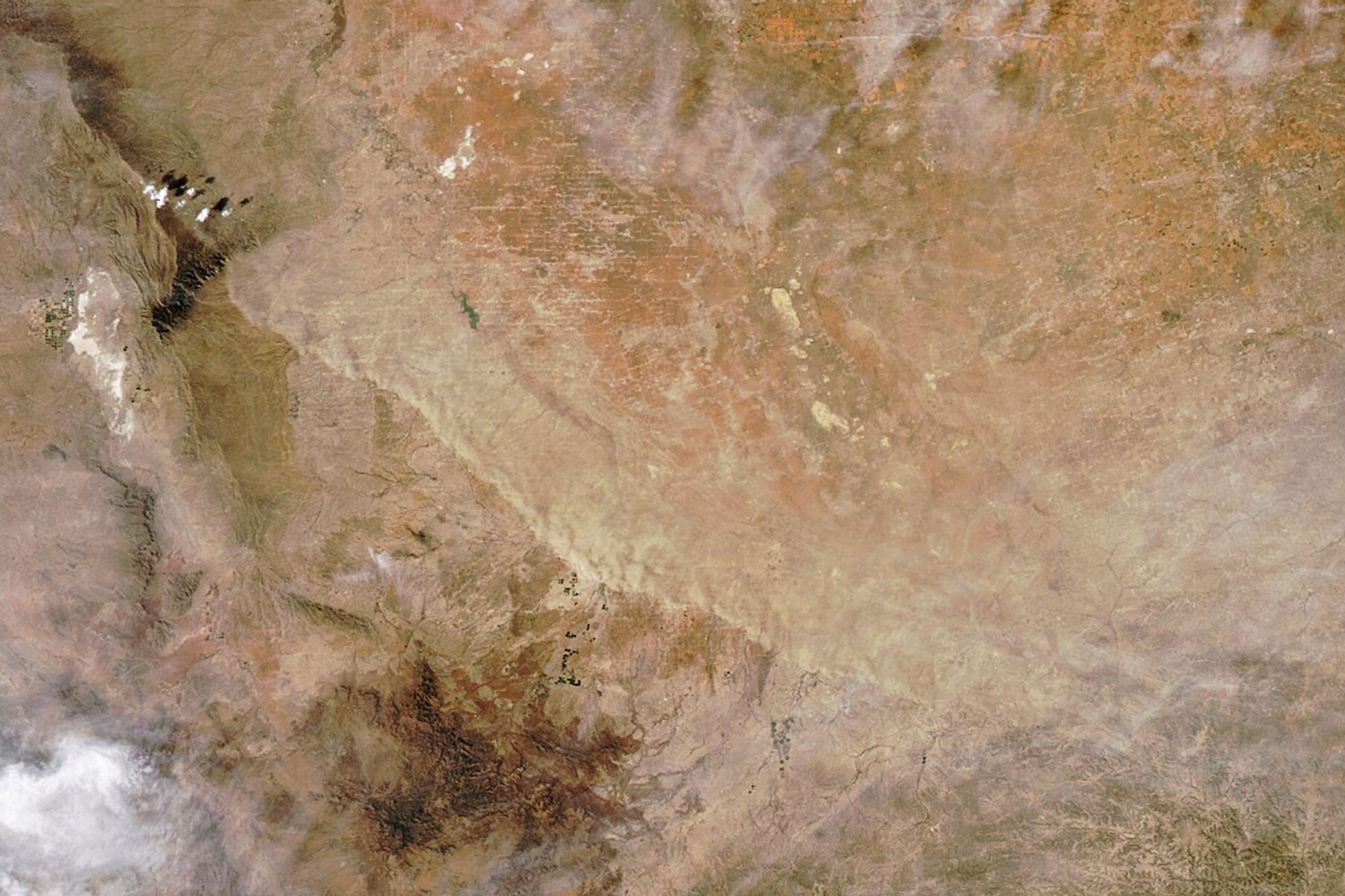 A line of tan suspended dust stretches roughly northwest-to-southeast for over 100 miles across West Texas.