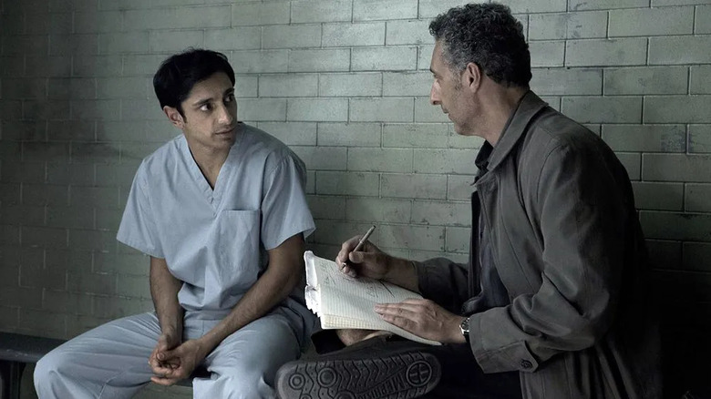 John Stone (John Turturro) writes notes while speaking with Naz Khan (Riz Ahmed) in a cell in The Night Of