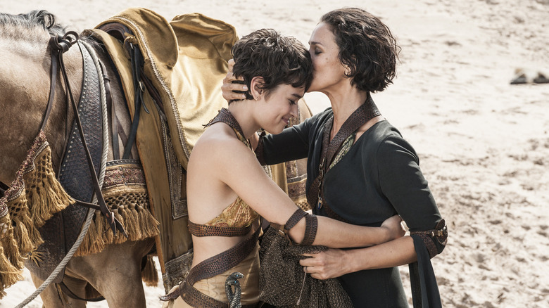 Rosabell Laurenti Sellers as Tyene Sand embracing Indira Varma as Ellaria Sand in a desert in Game of Thrones