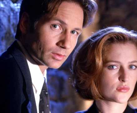 Mulder (David Duchovny) and Scully (Gillian Anderson) from 'The X-Files' both looking at the camera.