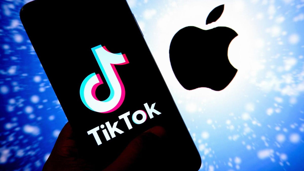 A TikTok logo on a black smart phone next to a black Apple logo on a sparkly blue background.